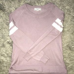 A light purple cardigan with white striped on arm